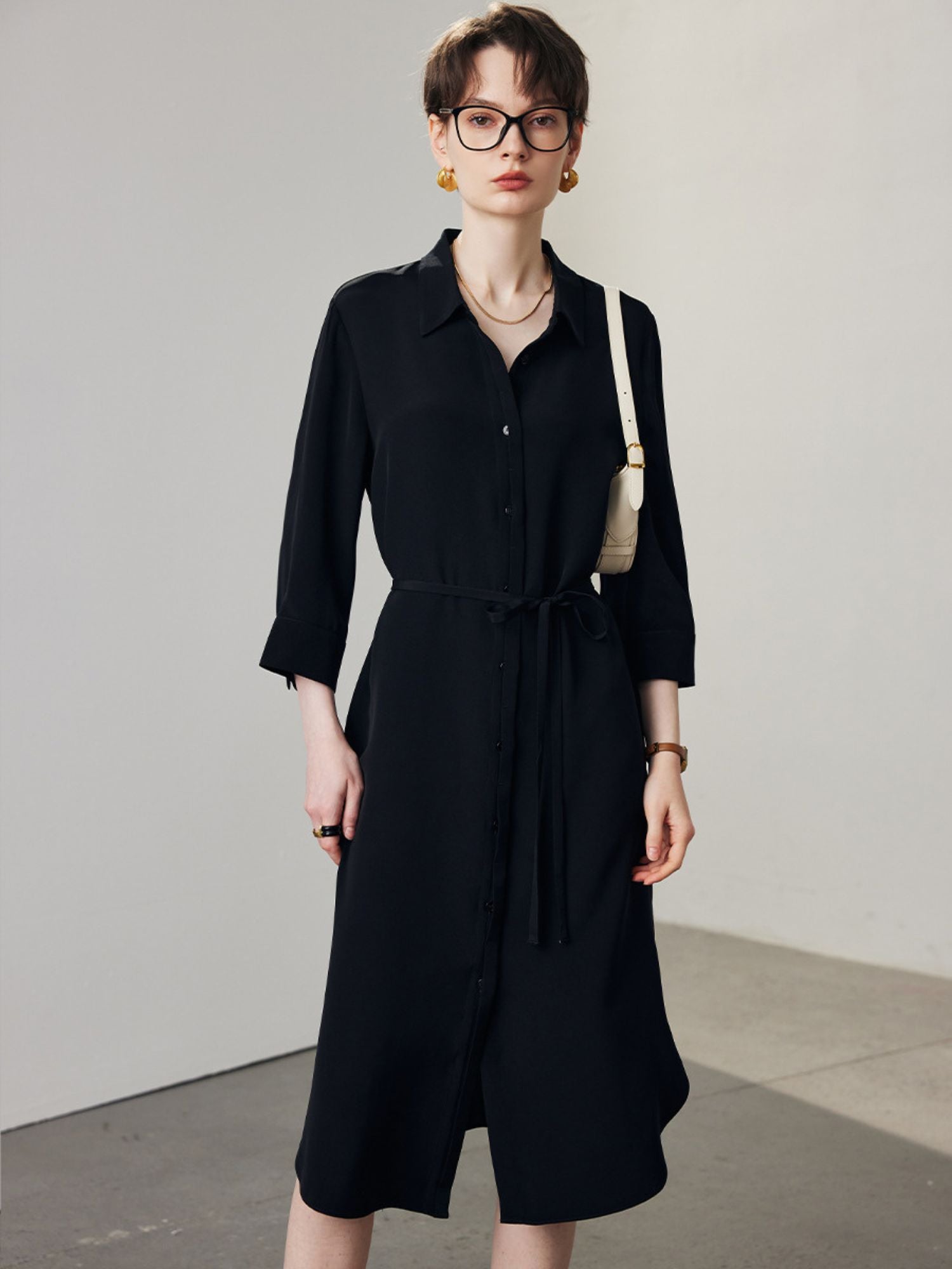 A woman wearing a beige shirt black.