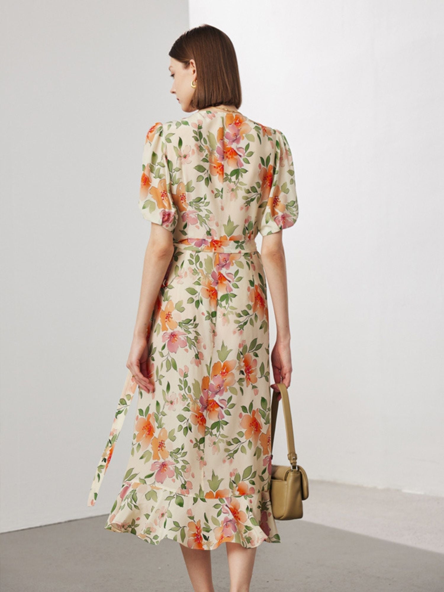 Back view of A woman wearing a wrap around floral dress.
