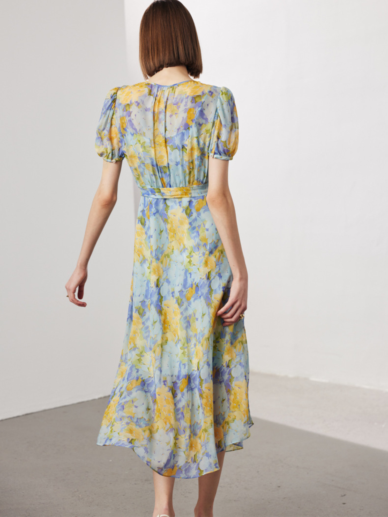 Back view of A woman wearing a floral dress.