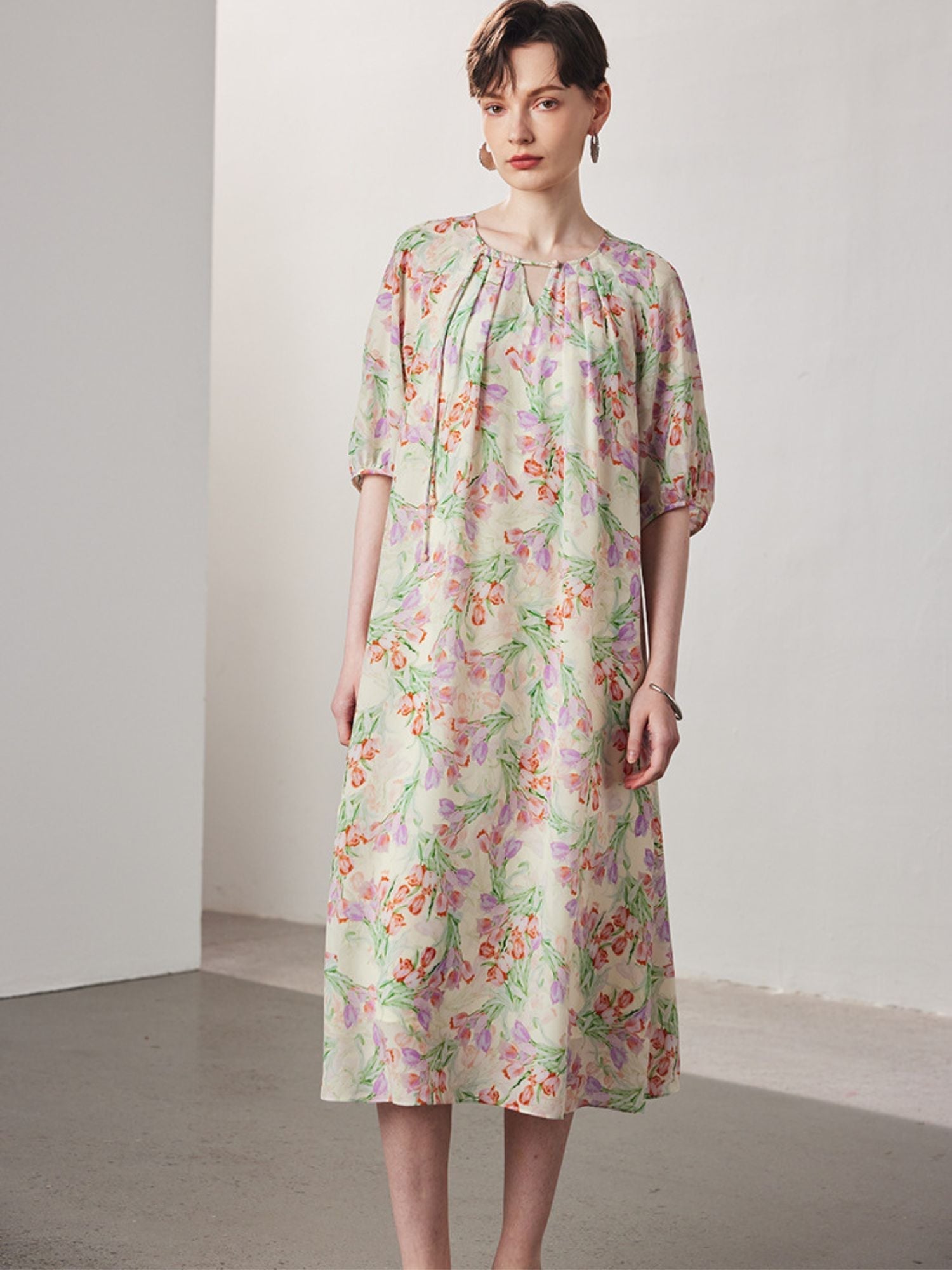 A woman with short hair wearing a floral dress.