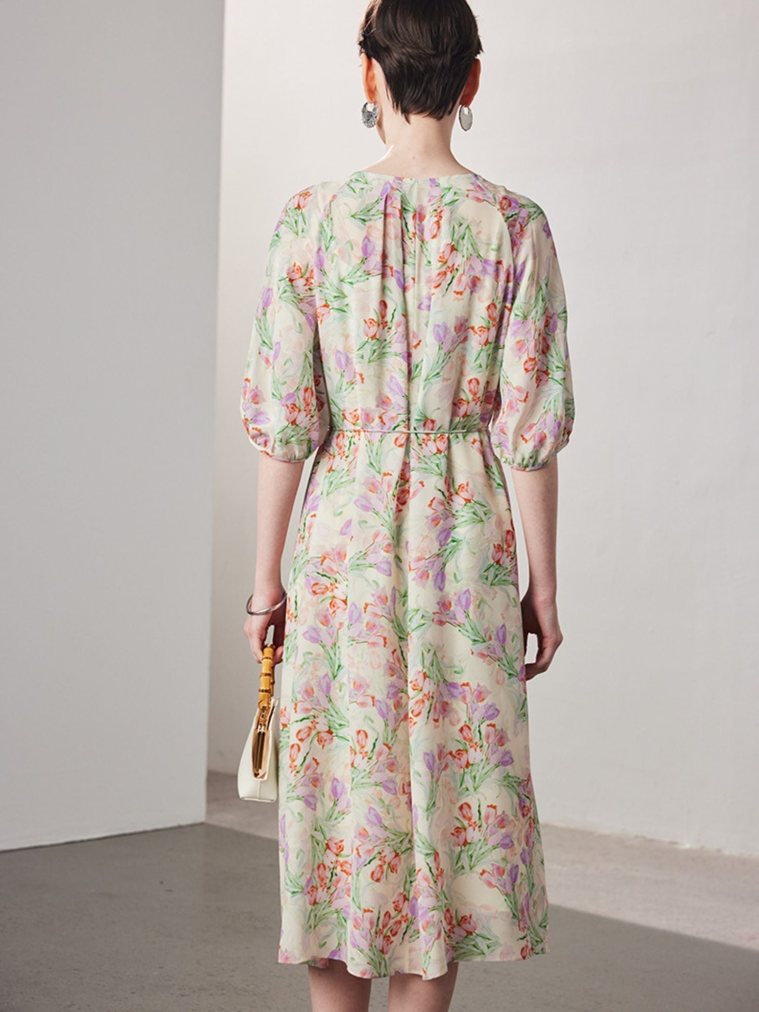Back view of A woman with short hair wearing a floral dress.