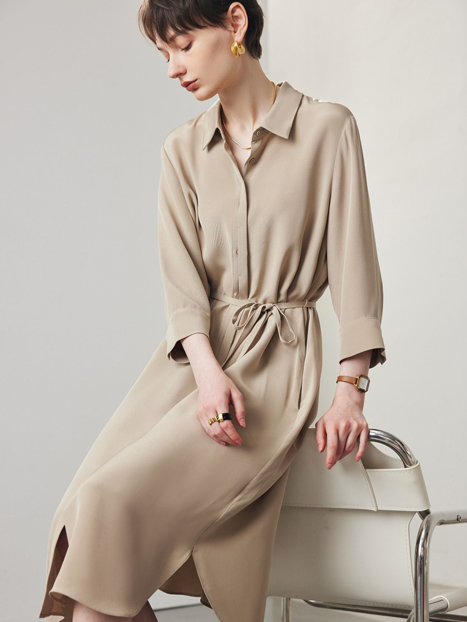 A woman wearing a beige shirt beige.